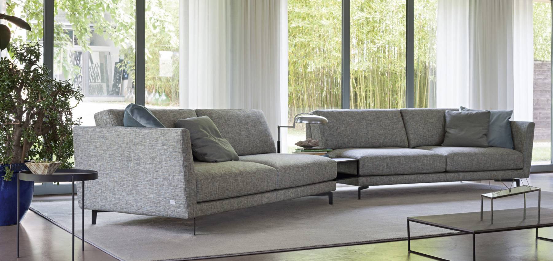 Divano Doimo Salotti modello Gregory, si distingue per la possibilità di inserire dei tavolini rettangolari/forme sagomate in metallo tra i 2 elementi.