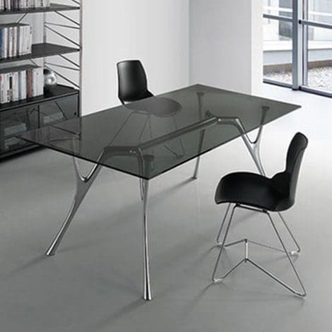 Tavolo Caimi modello Pegaso, design Angelotti & Cardile. Il tavolo ha il top in vetro temperato trasparente, con bordo molato a filo lucido.